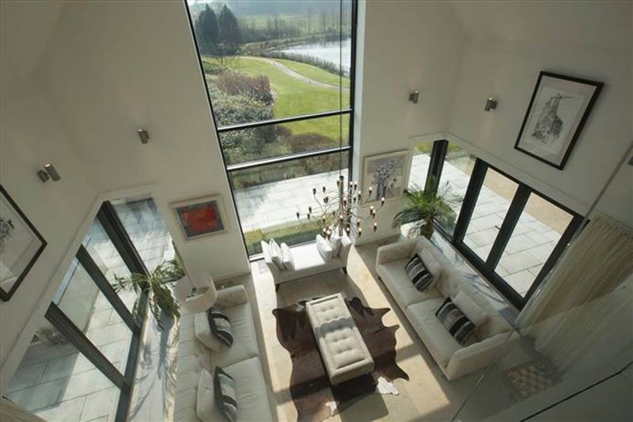 Una grande vetrata offre un panorama suggestivo dal salotto sul lago privato (da simonbrien.com)